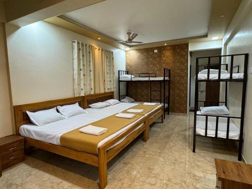 a bedroom with a bed and two bunk beds at Arav Resort in Katrab