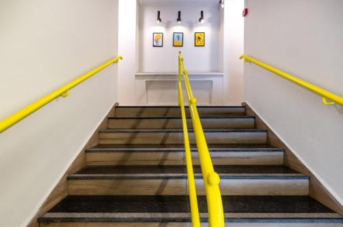 a staircase in a building with yellow railings at Degania Bet Kibbutz Country Lodging in Kinneret