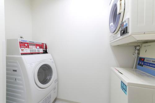 a washer and dryer in a laundry room at Just Inn Premium Nagoya Station in Nagoya
