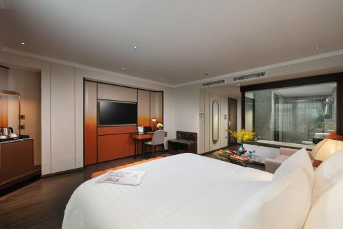 a hotel room with a large bed and a television at The Chi Boutique Hotel in Hanoi
