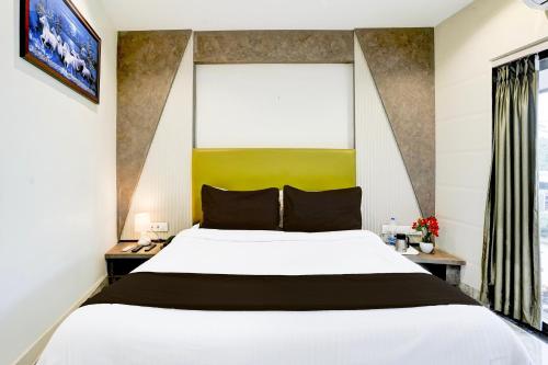 a bedroom with a large white bed and a window at Super Collection O Ghodbunder Road Formerly Sanwith Residency in Sasupāda
