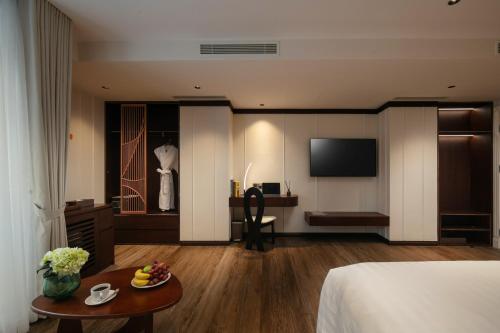 a hotel room with a bed and a table at The Chi Boutique Hotel in Hanoi