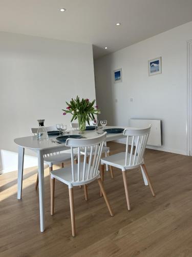 a dining room with a white table and chairs at Hardelot Face Mer in Hardelot-Plage