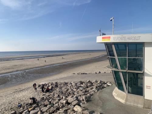 a building on a beach with people on the beach at Hardelot Face Mer in Hardelot-Plage