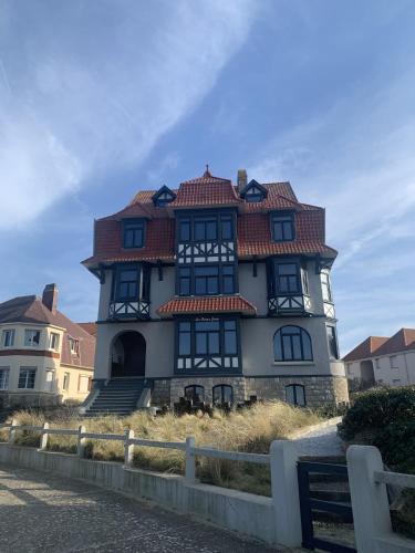 a large house with a red roof at Hardelot Face Mer in Hardelot-Plage