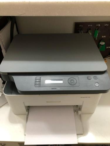 a laptop computer sitting on top of a printer at Skif Hotel in Astana