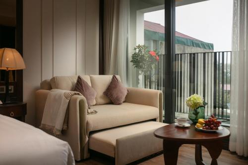 a living room with a couch and a large window at The Chi Boutique Hotel in Hanoi
