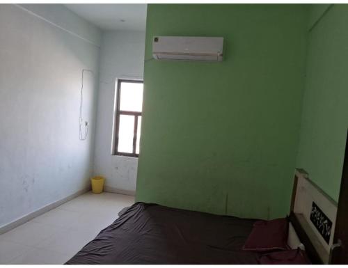 a room with a green wall and a bed at Hotel Yoran Inn, Baldeo in Baldeo