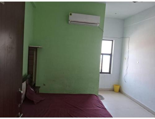 a room with a bed and a green wall at Hotel Yoran Inn, Baldeo in Baldeo