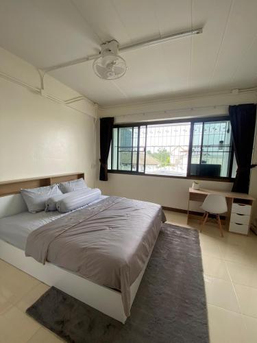 Un dormitorio con una cama grande y un escritorio. en Homey Place, en Ban Song Hong