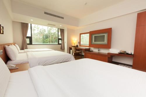 a hotel room with two beds and a television at F Hotel - Chiayi in Fanlu