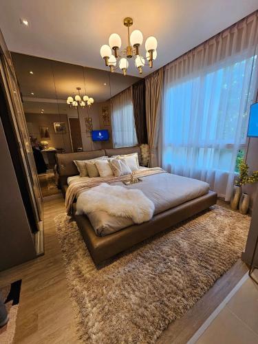 a bedroom with a large bed and a large window at The City Condo Near Central Fest Phuket, Pool view in Ban Sam Kong