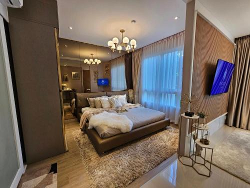 a bedroom with a large bed and a living room at The City Condo Near Central Fest Phuket, Pool view in Ban Sam Kong