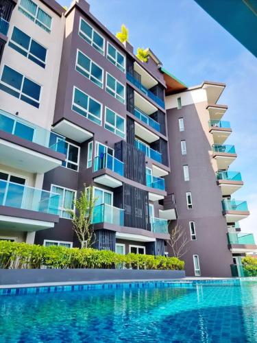 a large building with a swimming pool in front of it at The City Condo Near Central Fest Phuket, Pool view in Ban Sam Kong