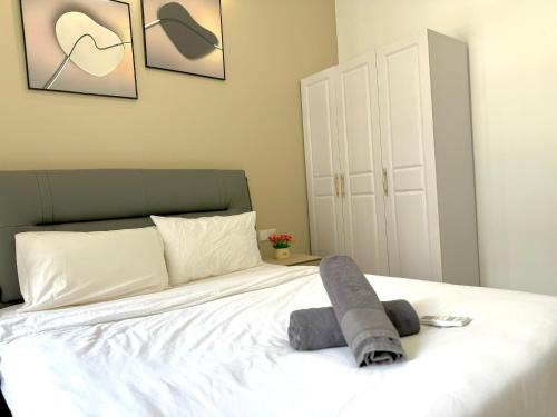 a bedroom with a bed with a gray towel on it at R&F Seine Region in Johor Bahru