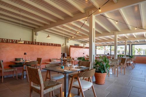 a dining room with tables and chairs and tablesktop at Akti Coast Club in Marmari