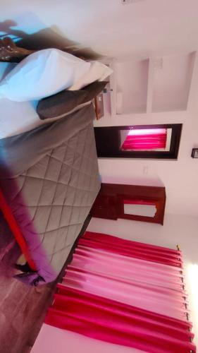 a bedroom with two bunk beds and a red rug at Sandcastle in Varkala