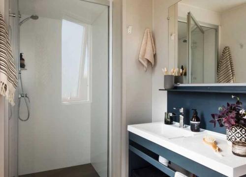 une salle de bain avec un lavabo blanc et un miroir dans l'établissement Camping - Parc aquatique - ccaggcd, à Olonne-sur-Mer
