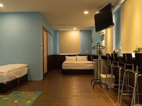 a room with two beds and a flat screen tv at Old Street Seaview Homestay in Jiufen