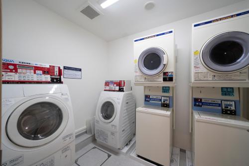 a laundry room with washing machines and a washer and dryer at Just Inn Premium Toyohashi Station in Toyohashi