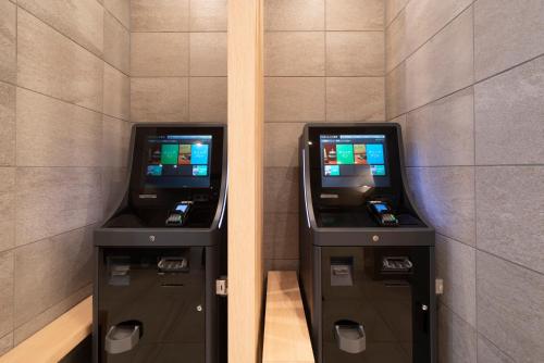 two atm machines sitting next to each other at Just Inn Premium Toyohashi Station in Toyohashi