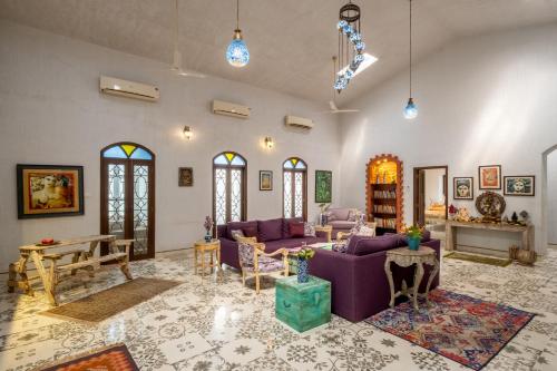 a living room with a purple couch and a table at The Inner Temple, Moira in Mapusa