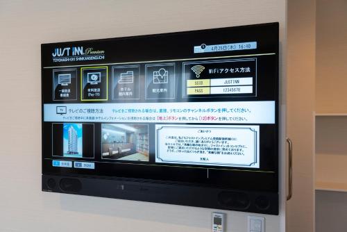a television screen on a wall in a room at Just Inn Premium Toyohashi Station in Toyohashi