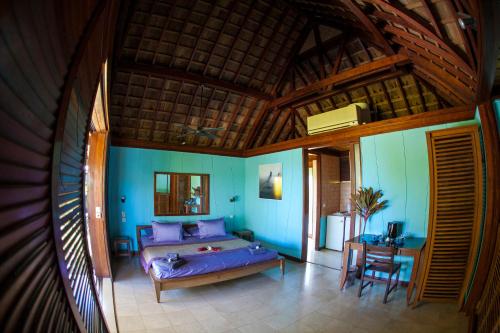 a room with a bed and a table in it at Oa Oa Lodge in Bora Bora