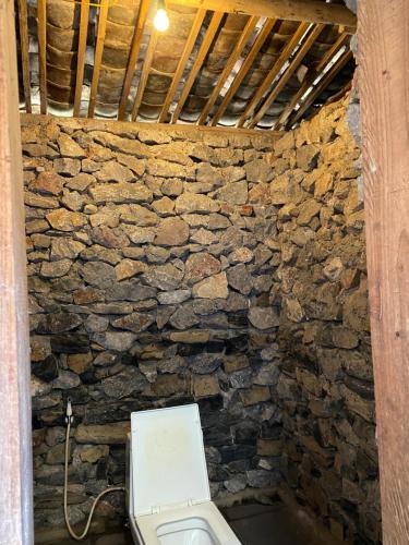 a stone bathroom with a toilet in a stone wall at Vieille Maison de Ma Lé in Mia Si