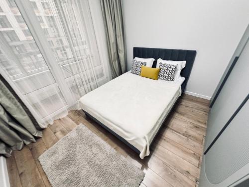 a small bedroom with a bed and a window at Ala Park apartment in Almaty
