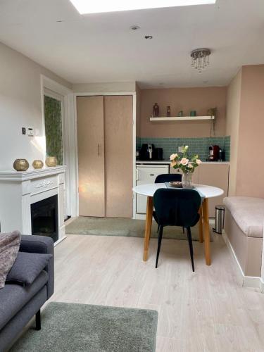 a living room with a table and a couch at Cozy and private apartment close to the city in Oss