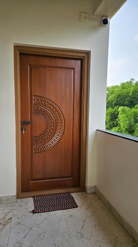 a wooden door with a spiral design on it at Mookambika Serviced Apartment in Coimbatore