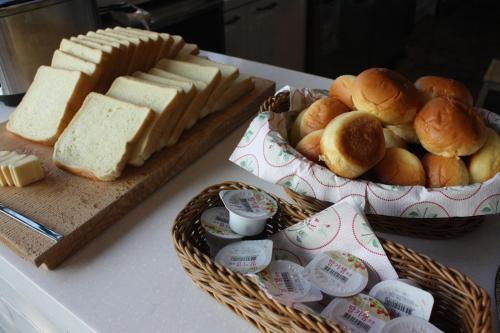 a table with two baskets of bread and sandwiches at Andong Poong-gyung HOSTEL n LIBRARY in Andong