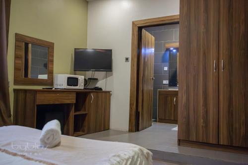 a room with a bedroom with a tv and a bed at Byblos Hotel-Sky Osu in Accra