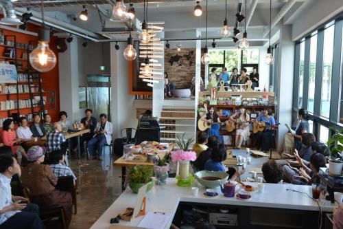 a group of people sitting at tables in a restaurant at Andong Poong-gyung HOSTEL n LIBRARY in Andong