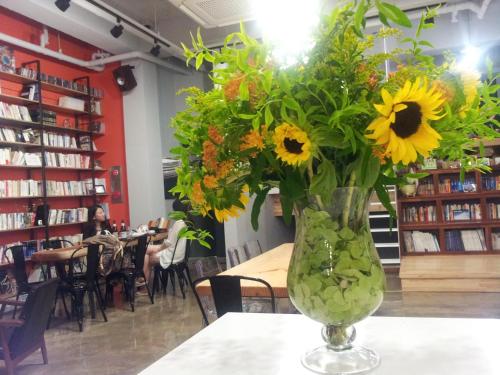 a vase filled with sunflowers sitting on a table at Andong Poong-gyung HOSTEL n LIBRARY in Andong