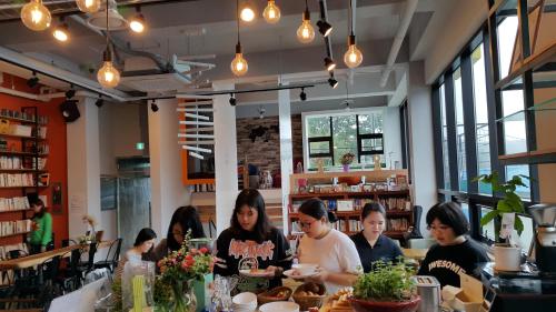 a group of people sitting at a table in a restaurant at Andong Poong-gyung HOSTEL n LIBRARY in Andong