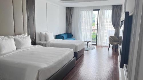 a hotel room with two beds and a window at OYSTER BAY HOTEL VUNG TAU in Vung Tau
