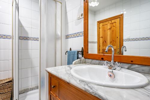 Un baño con lavabo, espejo y ducha. en La Cerra, en Pajares