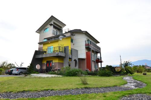 a building with a balcony on the side of it at Fuluart B&B in Dayin