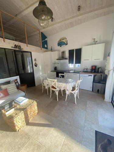une cuisine et un salon avec une table et des chaises dans l'établissement La cabane de Lily - T2 classé 3 étoiles, à Rochefort