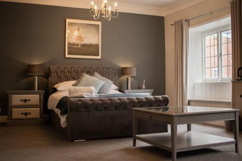 a bedroom with a bed and a couch and a table at The Bull in Battle