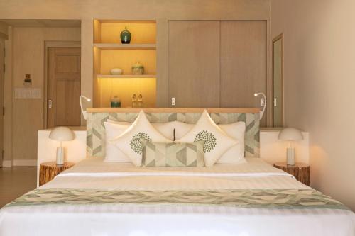a bedroom with a large white bed with pillows at Bandos Maldives in North Male Atoll