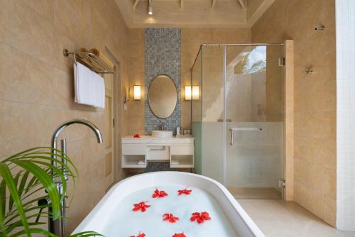 a bathroom with a bath tub and a shower at Bandos Maldives in North Male Atoll