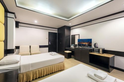 a hotel room with a bed and a television at THE Legacy convention hotel in Nonthaburi
