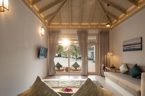 a living room with a couch and a window at Bandos Maldives in North Male Atoll