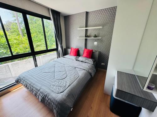 a bedroom with a bed with red pillows at The private paradise 2 in Pattaya North