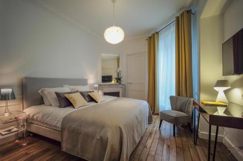 a bedroom with a bed and a desk and a chair at Relais12bis Bed & Breakfast By Eiffel Tower in Paris