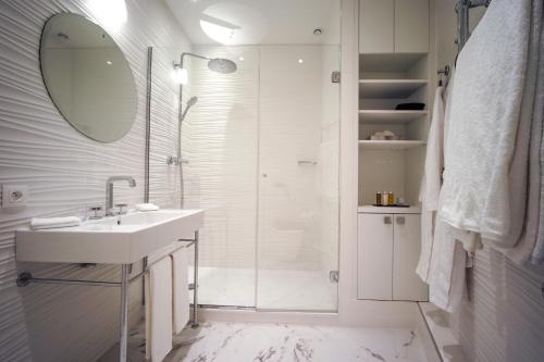 a white bathroom with a sink and a shower at Relais12bis Bed & Breakfast By Eiffel Tower in Paris