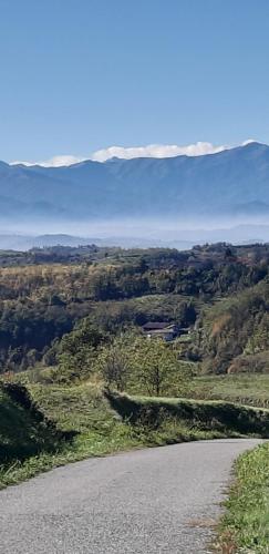 an empty road with mountains in the background at CASCINA BINELLO appartamenti A & B in Belvedere Langhe